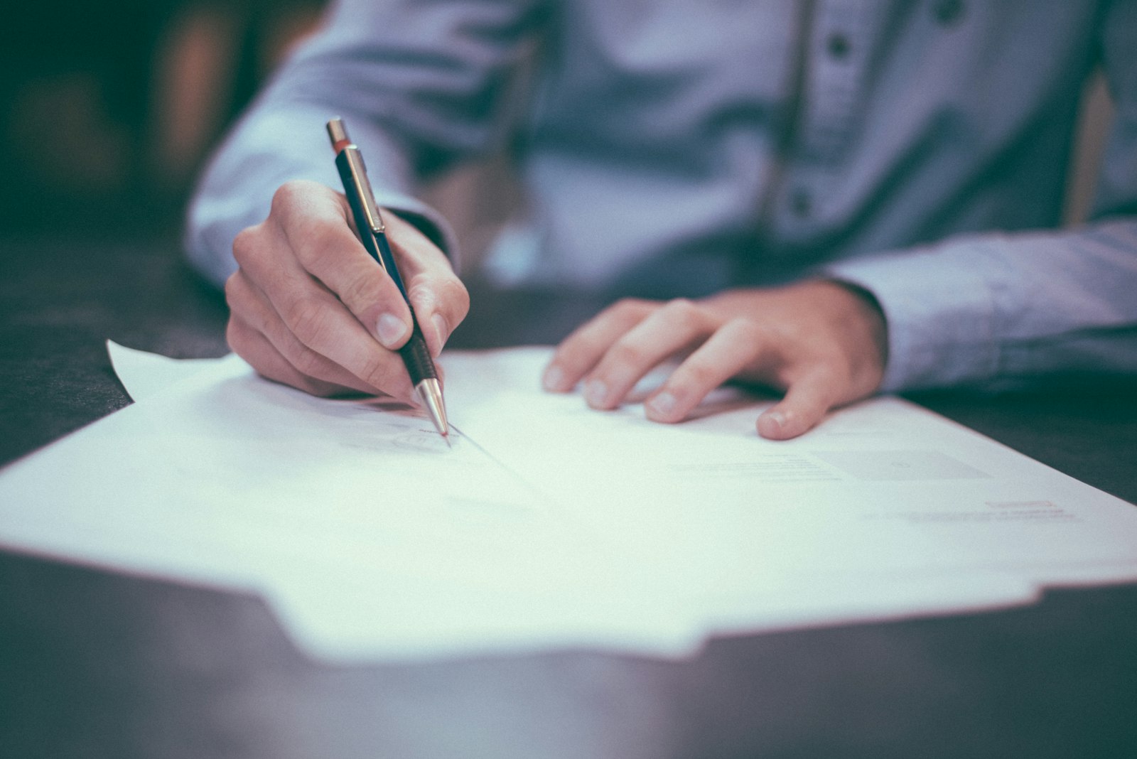 Homebuyer signing closing documents &mdash; Toronto land transfer tax and cashback rebate planning 2026